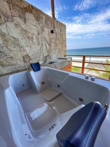 a bath tub with a sink and a view of the ocean at DIEM Vichayito Beachfront Eco-Luxury in Vichayito