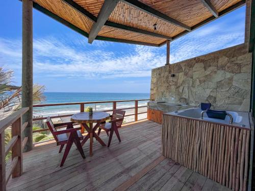 a deck with a table and a tub and the ocean at DIEM Vichayito Beachfront Eco-Luxury in Vichayito