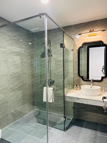 a bathroom with a glass shower and a sink at MOMALI Hotel Ninh Binh in Ninh Binh