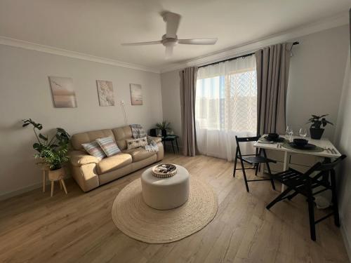 a living room with a couch and a table at Sussex Gem - Cozy apartment in the heart of Sussex in Sussex inlet