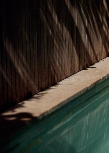 a wooden fence next to a swimming pool at 28 Degrees Byron Bay - Adults Only in Byron Bay