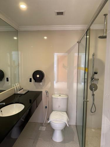a bathroom with a toilet and a sink and a shower at New Cape Inn in Singapore