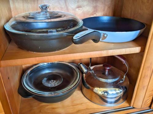 una mensola in legno con pentole, padelle, pentola e padella di ステイ和屋Ooasa徳島で家族とのんびりできる和室宿 a Naruto