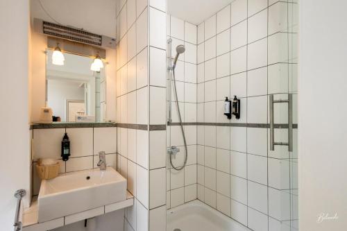 a white bathroom with a shower and a sink at la chocolaterie in Roly