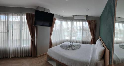 um quarto de hotel com uma cama, uma televisão e janelas em The Lux Ladprao 10 em Banguecoque