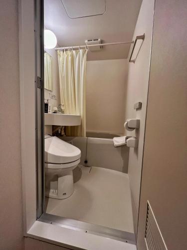a small bathroom with a toilet and a sink at Kansai Seaside Hotel in Kaizuka