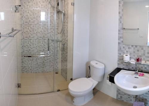 a bathroom with a toilet and a shower and a sink at The Lux Ladprao 10 in Bangkok