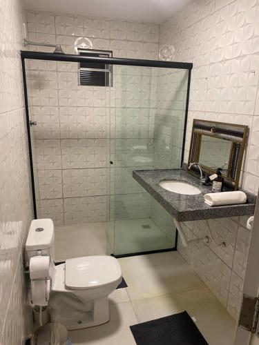a bathroom with a toilet and a sink and a mirror at Bangalô Dunas in Barreirinhas