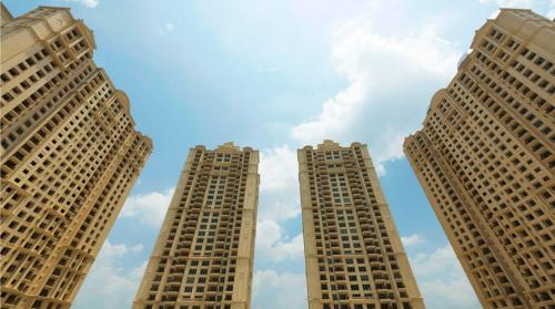 three tall buildings against a blue sky at Urban Stay Service Apartments Oragadam in Oragadam