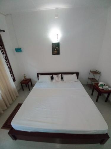 ein Schlafzimmer mit einem großen weißen Bett in einem Zimmer in der Unterkunft S & D Resort in Anuradhapura