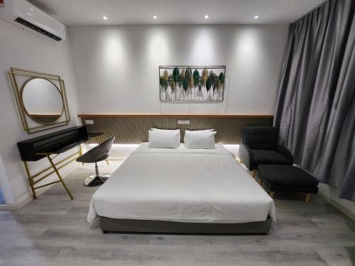 um quarto com uma cama, uma cadeira e um piano em One Point Hotel em Kuching