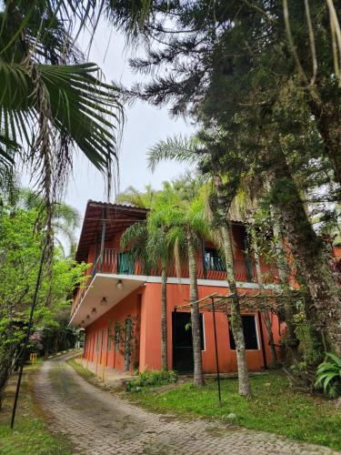 un edificio de naranjos con palmeras delante de él en POUSADA CANA DO REINO, en Embu