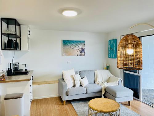 sala de estar con sofá y mesa en Breezy Ocean - The perfect getaway, en Mount Maunganui