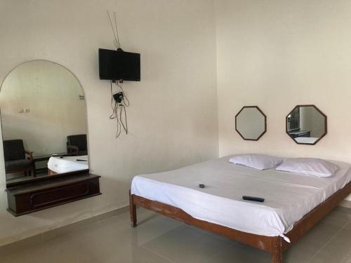 sypialnia z łóżkiem z lustrem i telewizorem w obiekcie Hotel Surya Citra Jogja A Mitra RedDoorz w mieście Timuran