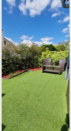 une pelouse avec deux chaises assises au-dessus dans l'établissement Charmante maison bien équipée, de bord de mer, à Royan
