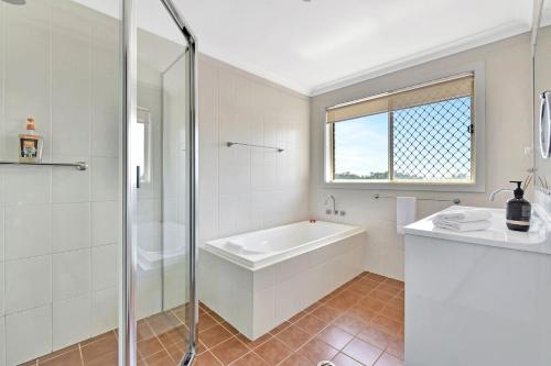 a bathroom with a tub and a sink and a shower at Noble Willow Estate in Lovedale