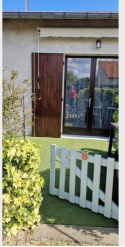 une clôture blanche devant une maison dans l'établissement Charmante maison bien équipée, de bord de mer, à Royan