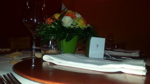 a table with a green vase with flowers on it at San Lorenzo Si Alberga in Camigliatello Silano