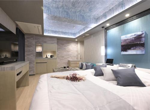 un grande letto bianco in una stanza con cucina di ホテル シードット 横浜 トレ a Yokohama