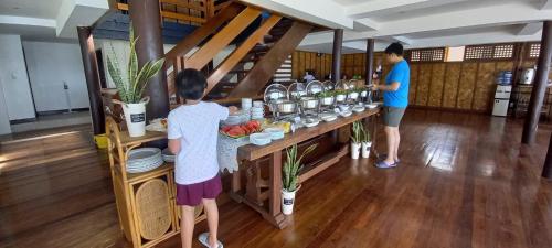 two people standing at a buffet in a room at Aquaventure Reef Club in Mabini