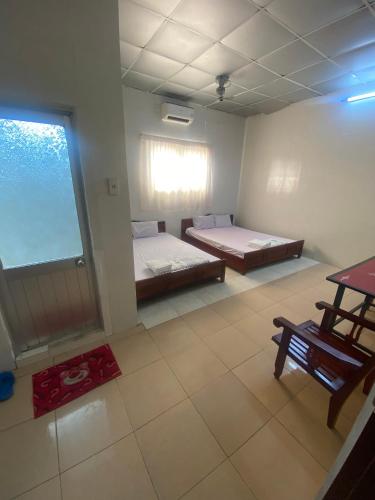 Zimmer mit 2 Betten und einem Fenster in der Unterkunft NHÀ NGHỈ LÊ TUẤN 