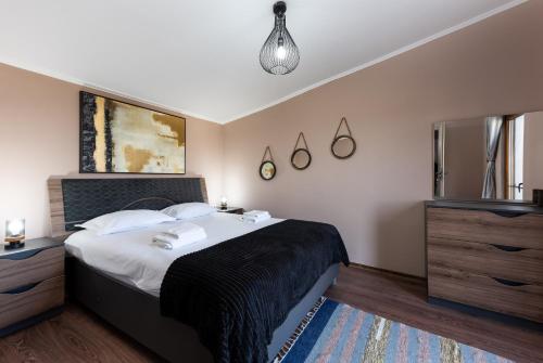 a bedroom with a large bed and a pendant light at Beaumont Lodges in Predeluţ