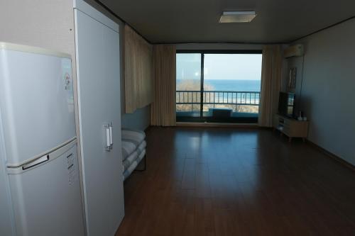 a room with a refrigerator and a large window at Mangsang Beach Pension in Gangneung