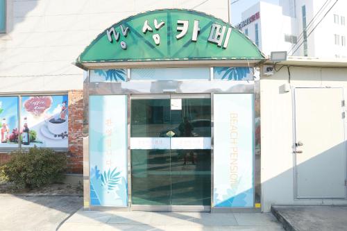 an entrance to a restaurant with a revolving door at Mangsang Beach Pension in Gangneung