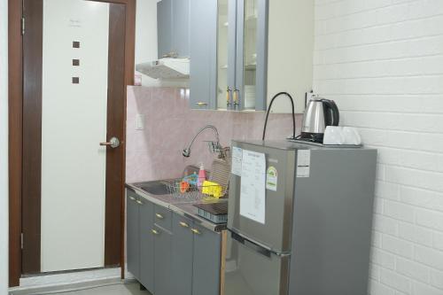 a kitchen with a sink and a refrigerator at Mangsang Beach Pension in Gangneung