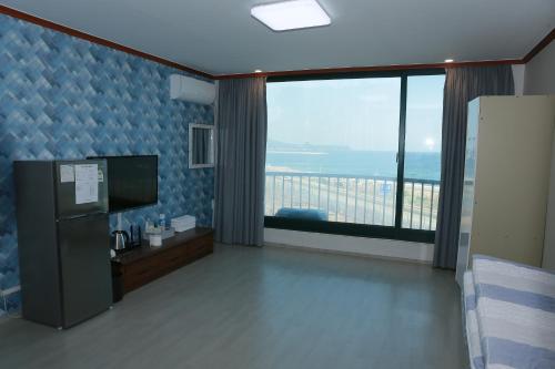 江陵市にあるMangsang Beach Pensionの海の景色を望む大きな窓が備わる客室です。