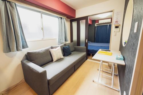 a living room with a couch and a table at MELL-THEATE - Nibiironokaze - in Osaka