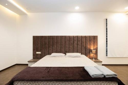 a bedroom with a large bed with two towels on it at Family&PetFriendly 5BHK With Jacuzzi @BanjaraHills in Hyderabad