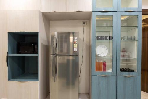 a kitchen with a stainless steel refrigerator and a blue cabinet at Family&PetFriendly 5BHK With Jacuzzi @BanjaraHills in Hyderabad