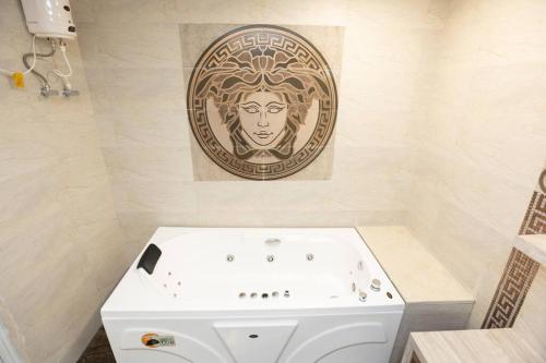 a bathroom with a white tub and a painting on the wall at Family&PetFriendly 5BHK With Jacuzzi @BanjaraHills in Hyderabad