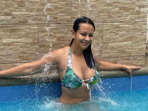 une jeune femme dans une piscine d'eau dans l'établissement HOSTAL SAN MARINO, à Manta