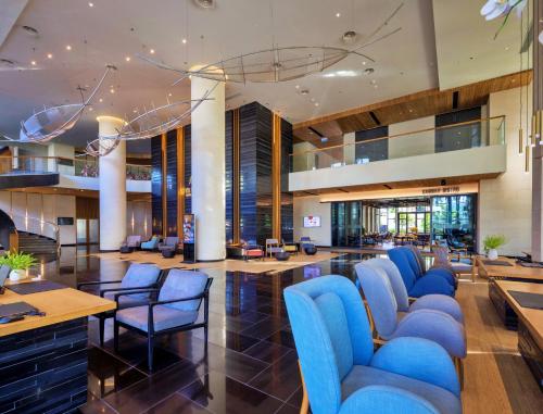 a lobby with blue chairs and tables at Anya Premier Hotel Quy Nhon in Quy Nhon