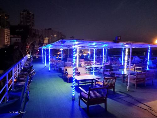 a deck with tables and chairs with blue lights at مركب ريفر River Boat in Cairo