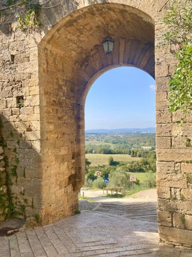 an archway in a stone wall with a view at Monteriggioni Castello in Monteriggioni