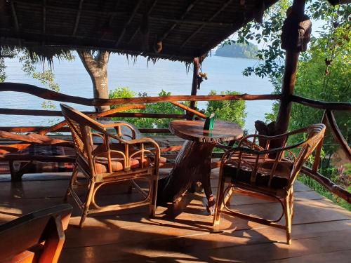 una mesa y sillas en un porche con vistas al agua en Littleduck bungalow Koh Chang Ranong, en Koh Chang