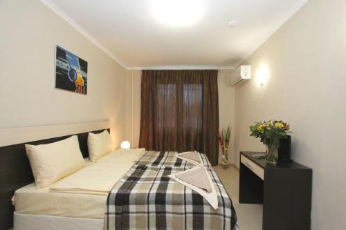 1 dormitorio con 1 cama y 1 mesa con flores en Hotel Dali, en Balashikha