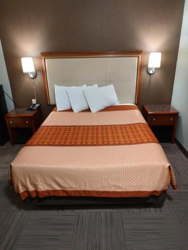 a bedroom with a large bed with two night stands at Economy Inn Richmond in Richmond