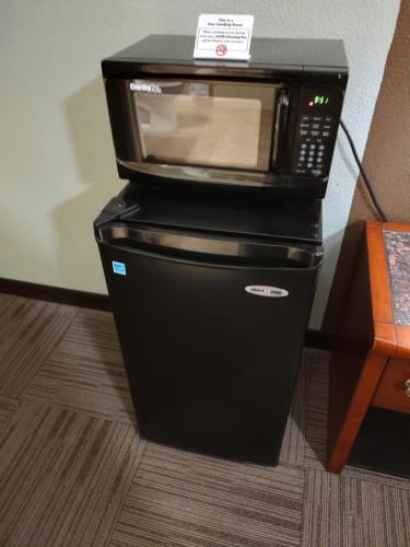 a black microwave sitting on top of a refrigerator at Economy Inn Richmond in Richmond