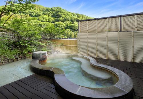 a hot tub in the middle of a patio at Tachibanaya in Tsuruoka