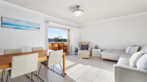 a dining room with a table and a couch at Cumbernauld #20 Ocean Views, Wifi Accom Holidays in Terrigal