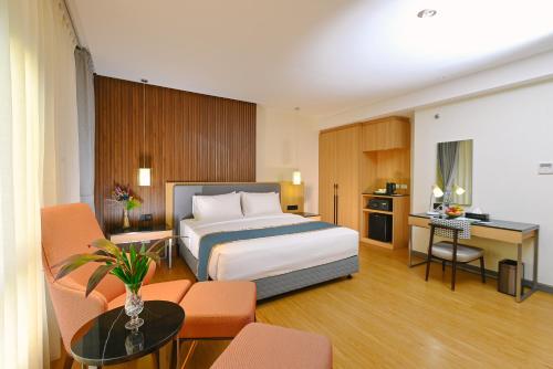 ein Hotelzimmer mit einem Bett und einem Schreibtisch in der Unterkunft Ardenhills Suites in Manila