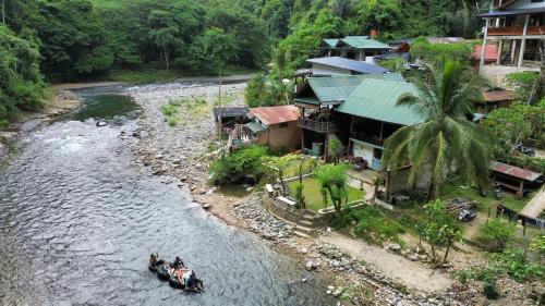 a group of people riding on a boat in a river at Sam's Bungalows And Treks in Bukit Lawang