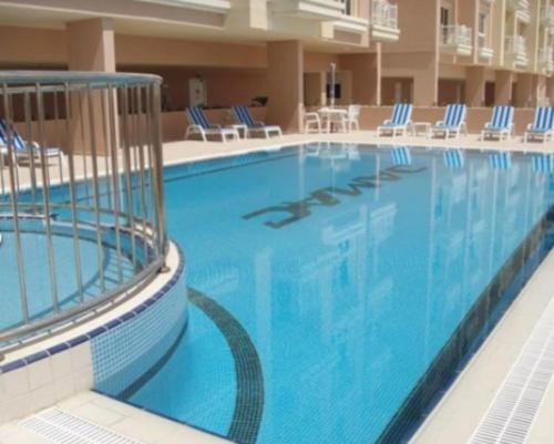 uma grande piscina com cadeiras azuis num hotel em Huge Entire apartment for Couples ,families & Groups -up to 5 Guests- with free pool, steam & Sauna ,JVC,Dubai em Dubai