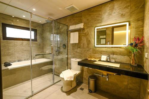 a bathroom with a shower and a toilet and a sink at Ardenhills Suites in Manila