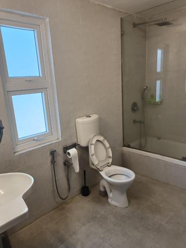 a bathroom with a toilet and a sink and a window at Chai Seeds Resort in Mākum