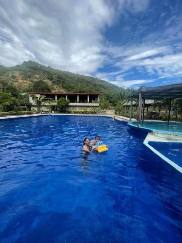 zwei Personen im Wasser in einem Pool in der Unterkunft Sevilleja's farm danglas abra in Bangued